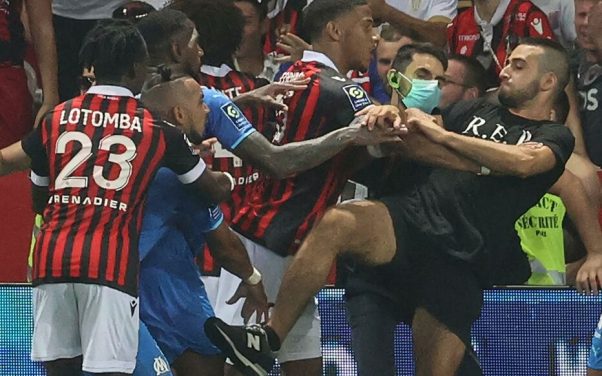 Marseille's French midfielder Dimitri Payet (2nd L) reacts as players from OGC Nice (red and black jersey) and Olympique de Marseille (blue jersey) stop a fan invading the pitch  during the French L1 football match between OGC Nice and Olympique de Marseille (OM) at the Allianz Riviera stadium in Nice, southern France on August 22, 2021. - The French Ligue 1 game between Nice and Marseille was halted on August 22, 2021, when fans of the home side invaded the pitch and angrily confronted opposing player Dimitri Payet. An AFP journalist at the game said trouble flared in the 75th minute when Marseille star Payet, who had been targeted by plastic bottles every time he took a corner, lobbed one back into the stands. (Photo by Valery HACHE / AFP)