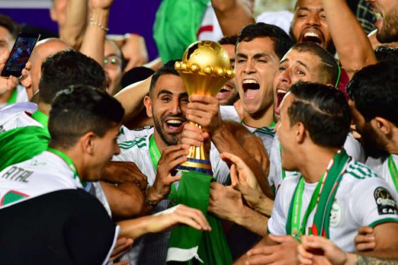 Algeria's forward Riyad Mahrez and his teammates celebrate with the trophy after winning the 2019 Africa Cup of Nations (CAN) Final football match between Senegal and Algeria at the Cairo International Stadium in Cairo on July 19, 2019. (Photo by Giuseppe CACACE / AFP)
