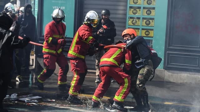 Une manifestante s’en prend physiquement à un pompier lors du défilé du 1er mai