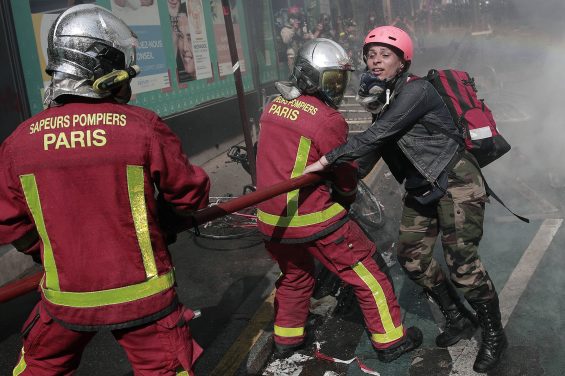 A demonstrator prevents firefighters from extinguishing garbage and materials that was put on fire during a May Day demonstration march from Republique, Bastille to Nation, in Paris, France, Sunday, May 1, 2022. Citizens and trade unions in France take to the streets to put out protest messages to their governments as a rallying cry against newly reelected President Emmanuel Macron. (AP Photo/Lewis Joly)/XFM128/22121564528575//2205011743