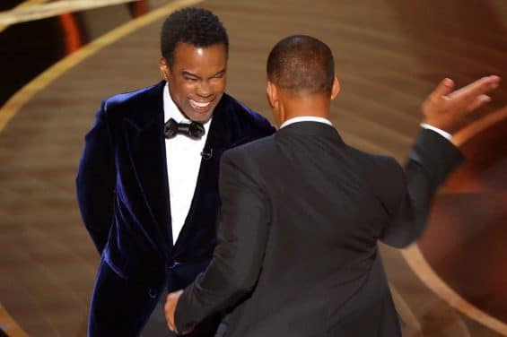 Will Smith (R) hits Chris Rock as Rock spoke on stage during the 94th Academy Awards in Hollywood, Los Angeles, California, U.S., March 27, 2022. REUTERS/Brian Snyder